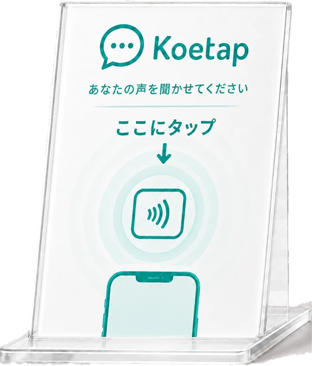 卓上のNFCスタンド。「あなたの声を聞かせてください／ここにタップ」と書かれたアクリル製